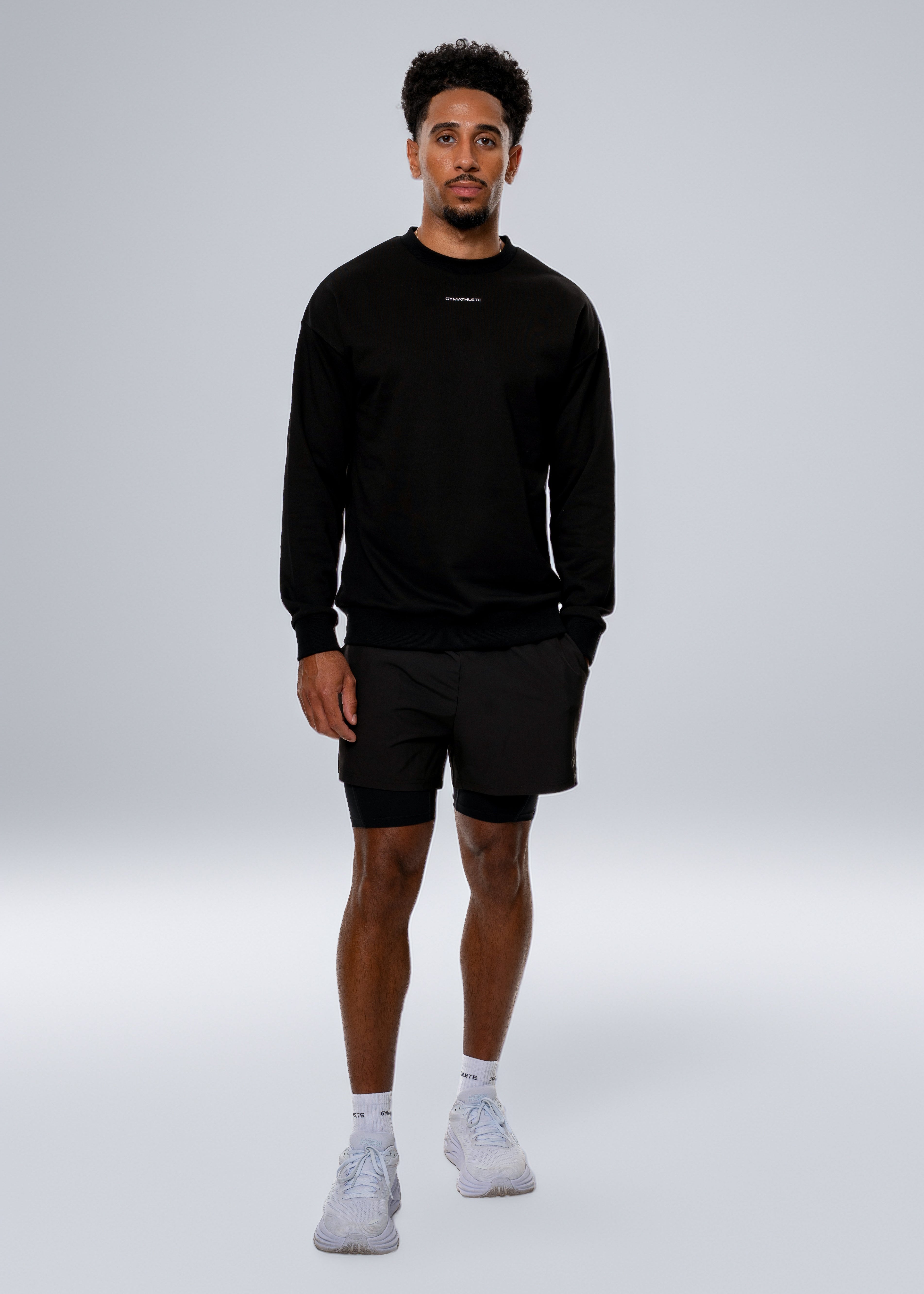 Person wearing a black sweatshirt and shorts on a gray background - Gymathlete 2in1 shorts