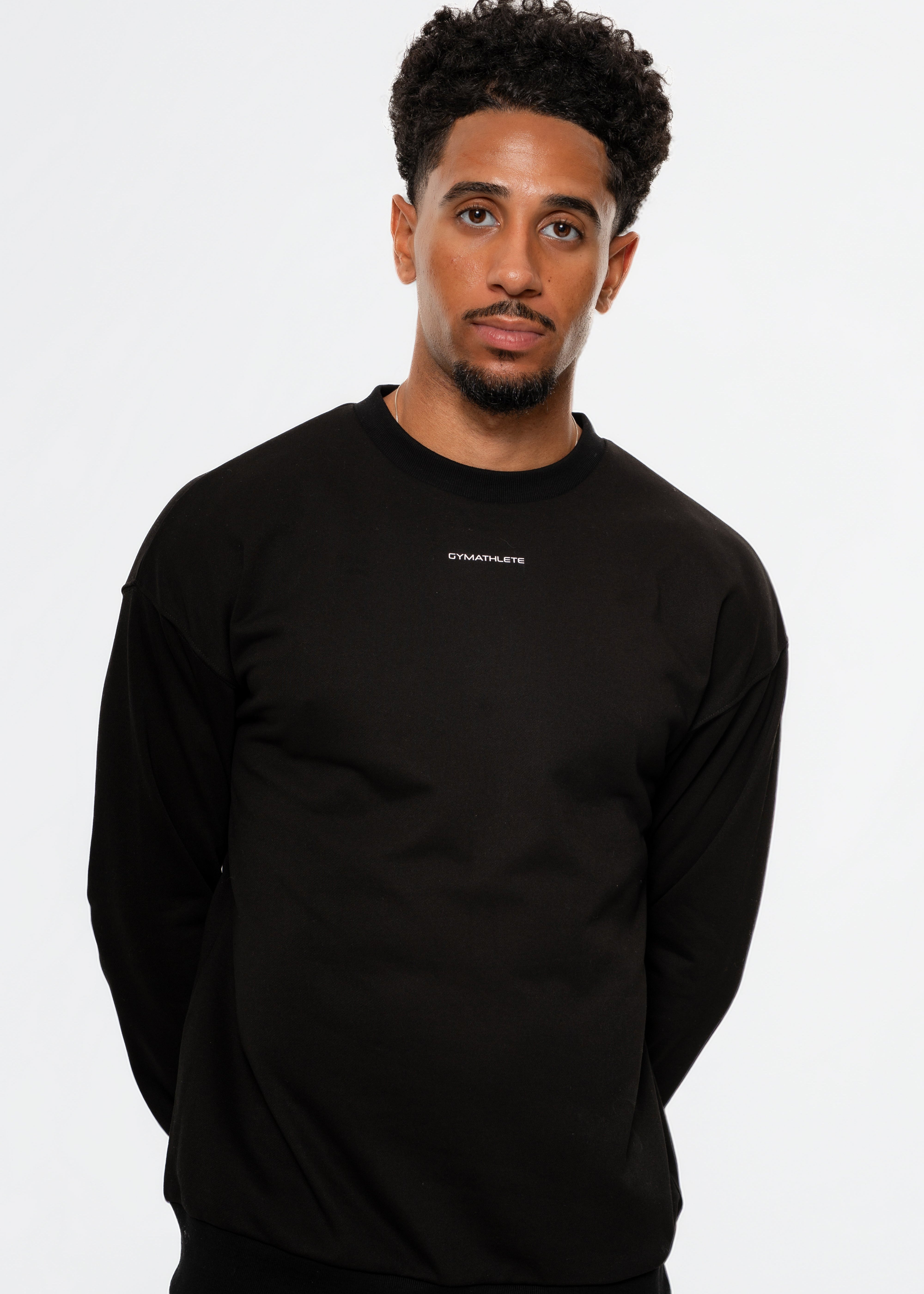Man wearing a black sweatshirt and shorts with white socks on a white background. Gymathlete, Eelevate Sweatshirt