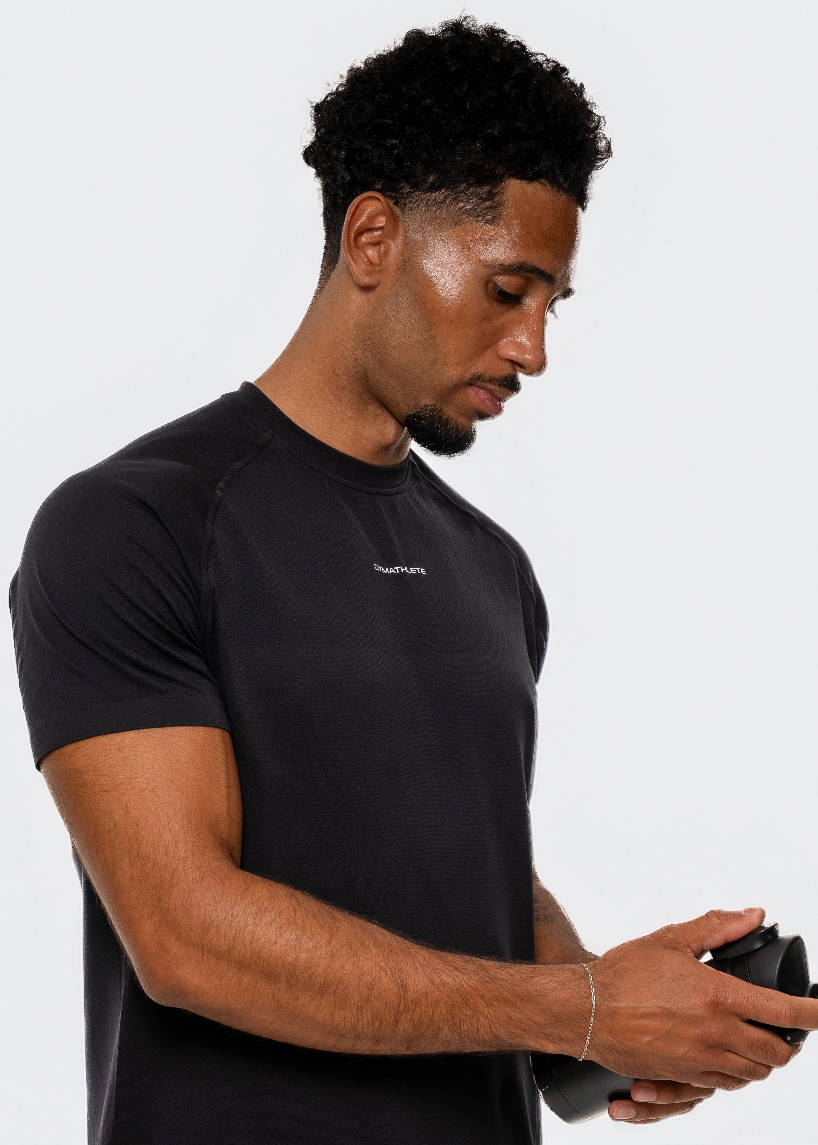 Man wearing a black t-shirt with a logo on a white background. Gymathlete Elevate t-shirt