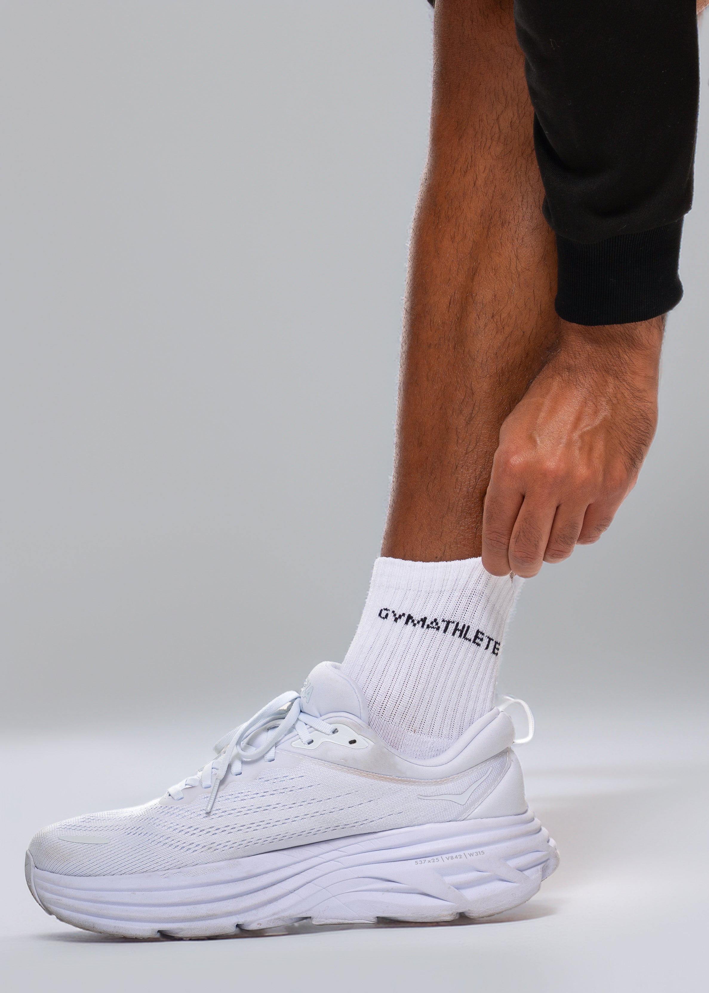 White sneaker and sock with 'GYMATHLETES' branding on a gray background - Gymathlete endurance socks