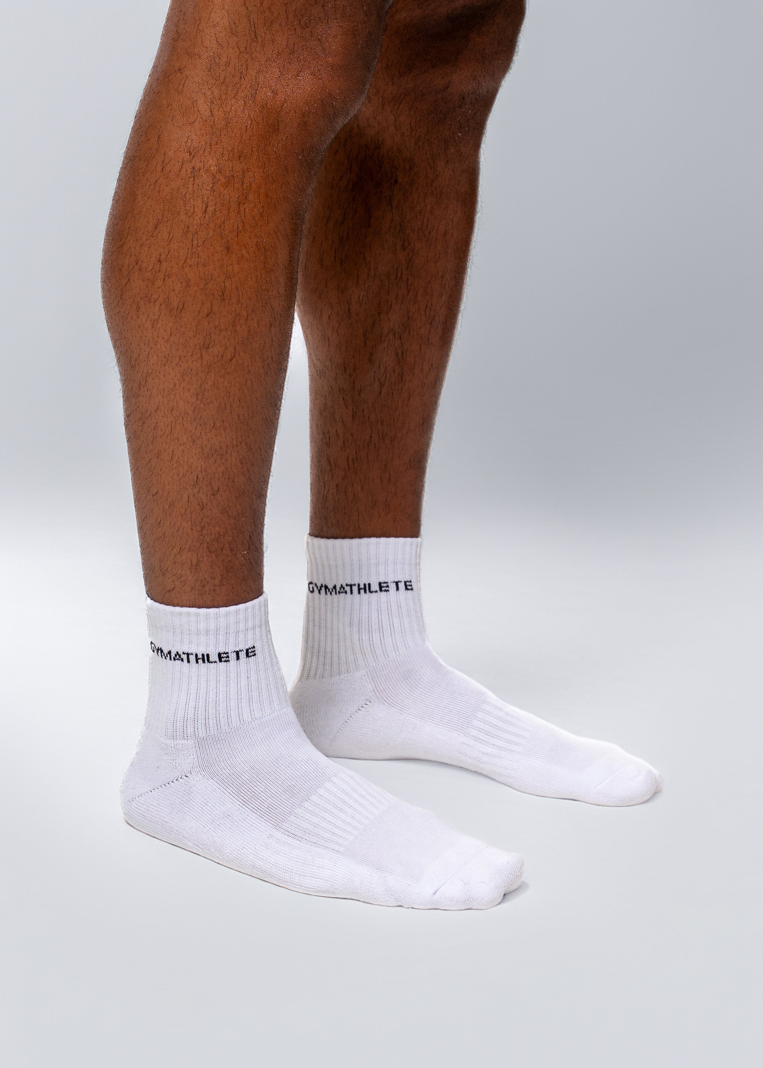 White socks with brand logo worn by a person on a light gray background - Gymathlete endurance socks