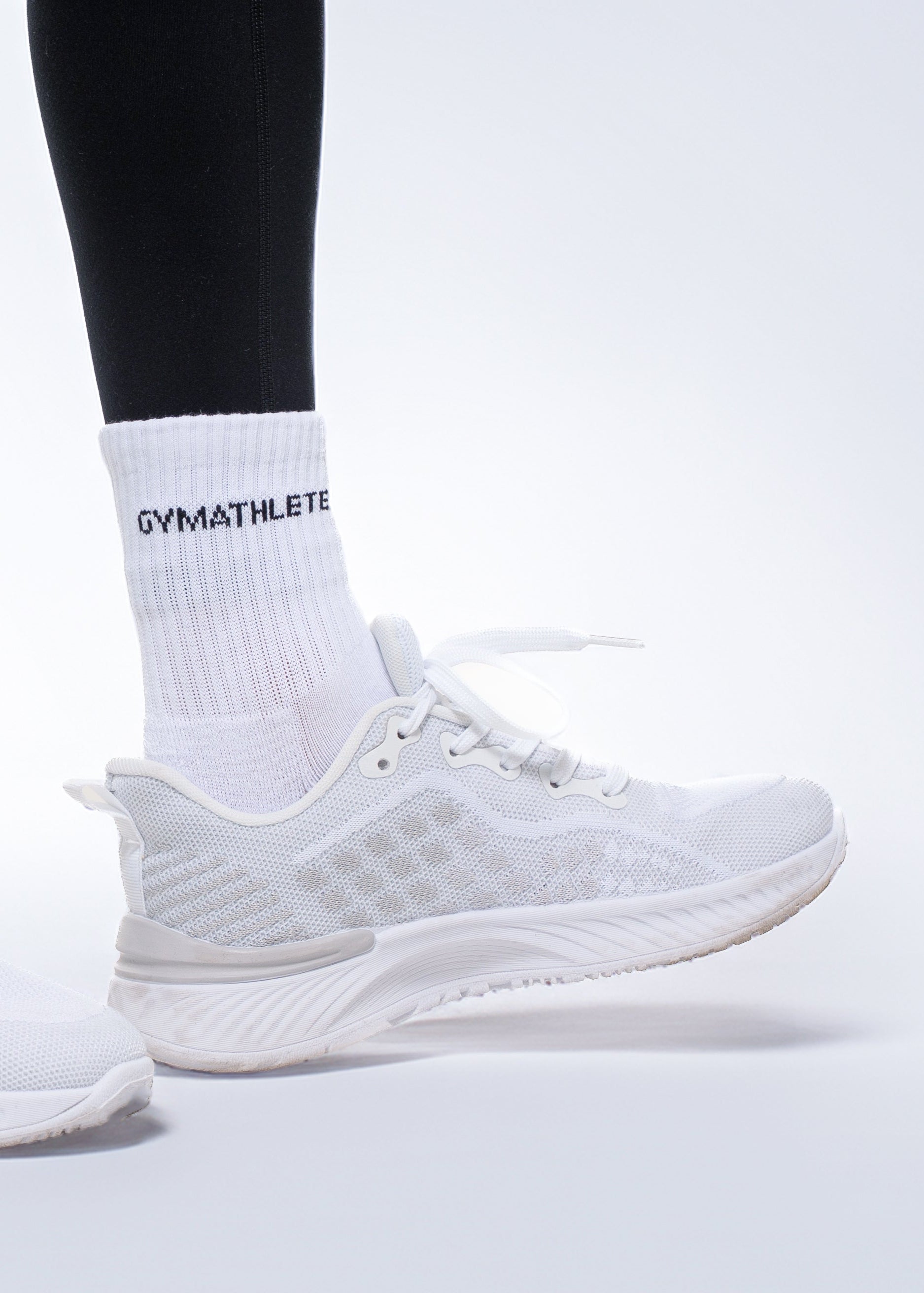 White athletic shoes and socks with 'GYMATHLETE' branding on a light gray background. Gymathlete - Endurance socks - women