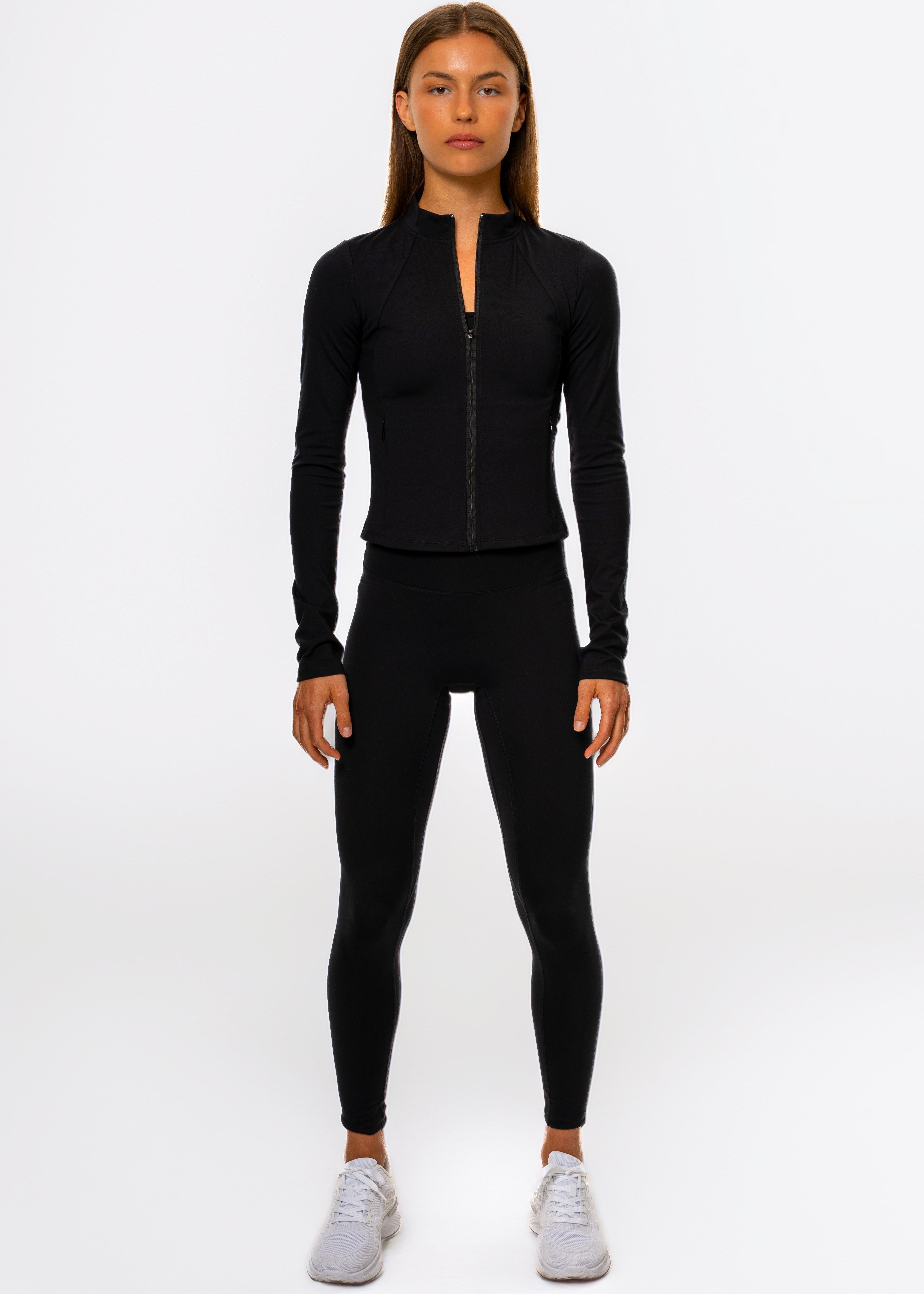 Person wearing a black athletic outfit on a white background. Gymathlete Pulse leggings