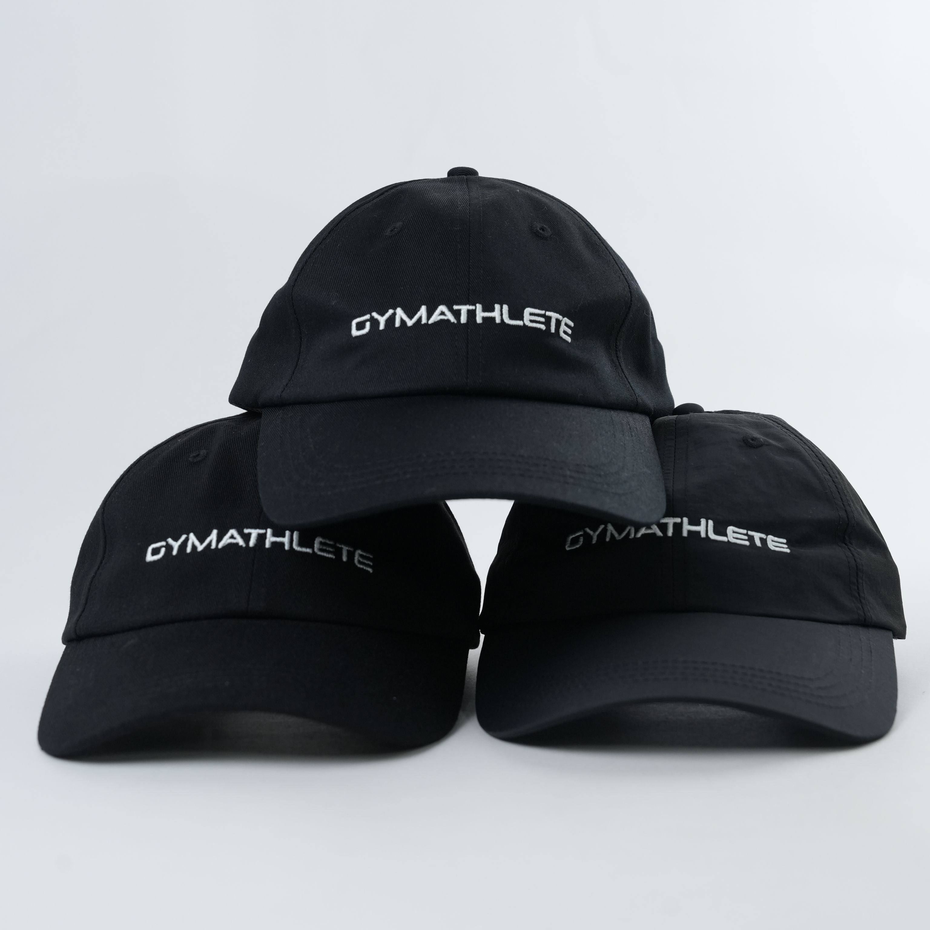 Three Gymathlete Peak Organic Caps stacked together, highlighting minimalist design and sustainable materials for active lifestyles.
