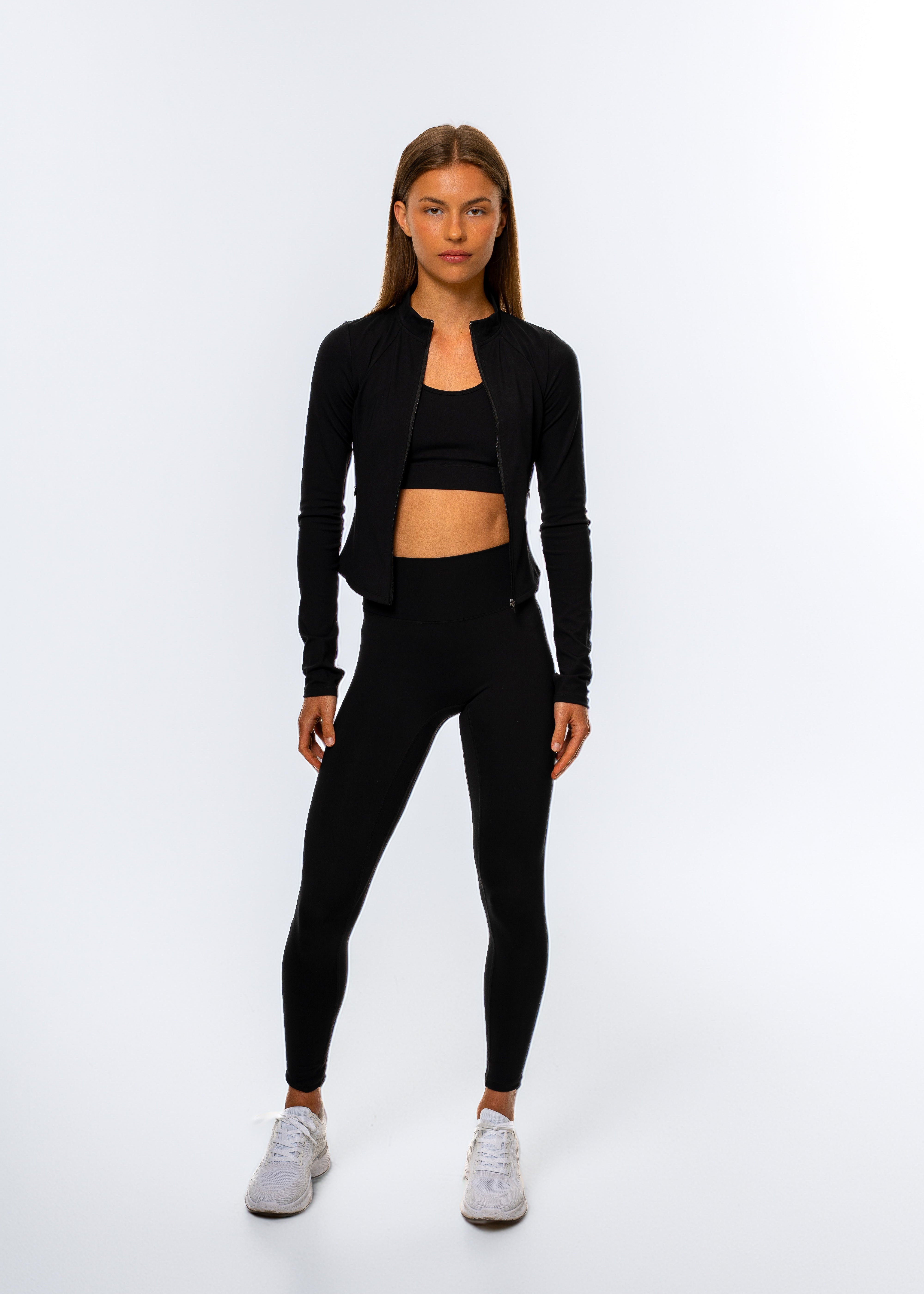 Woman wearing the Gymathlete Pulse Active Jacket in black.