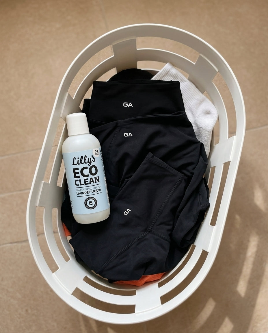 Black leggings and gym clothes in a laundry basket with mild eco detergent