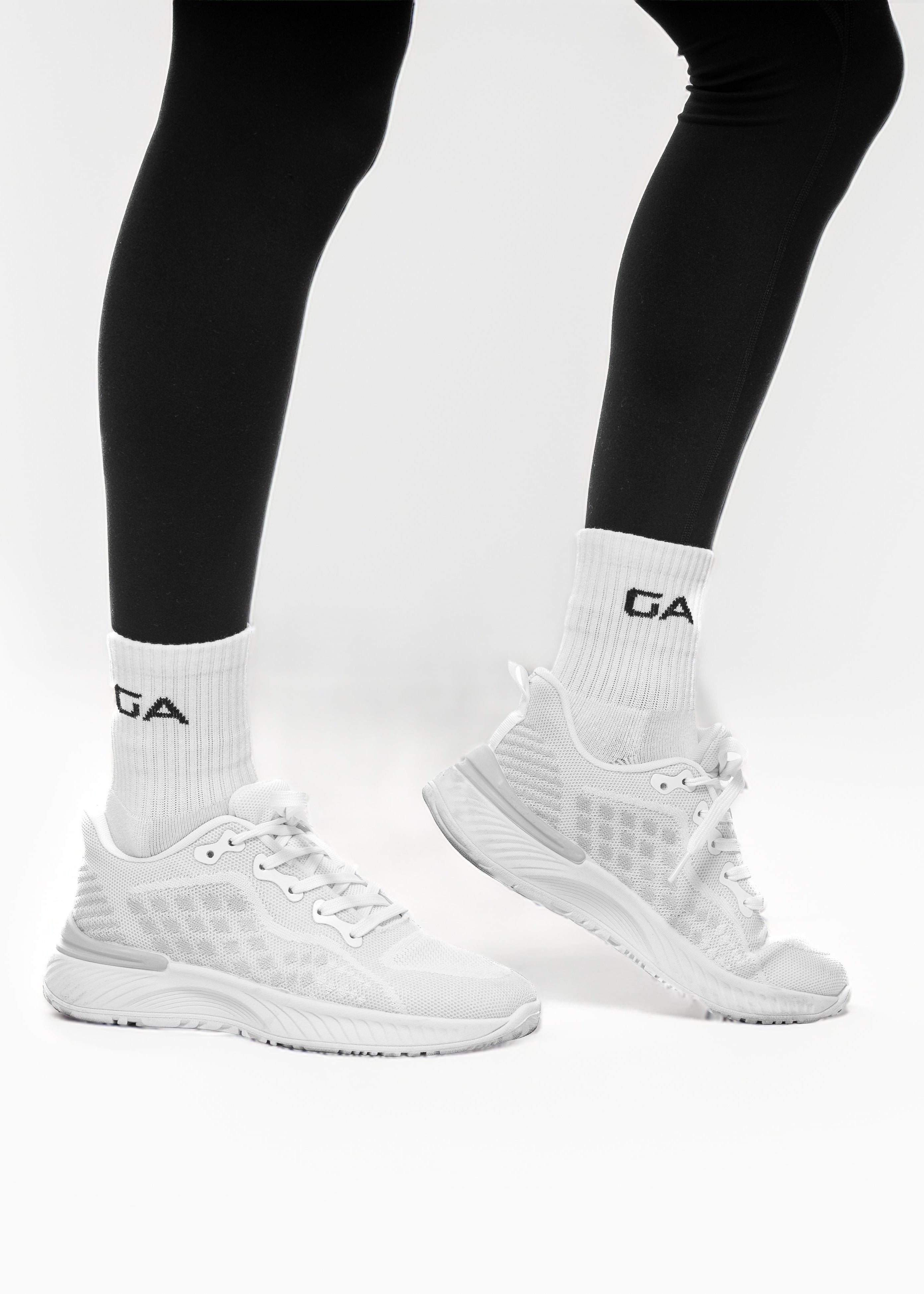 White sneakers with black socks featuring a brand logo on a white background. GA endurance socks - women