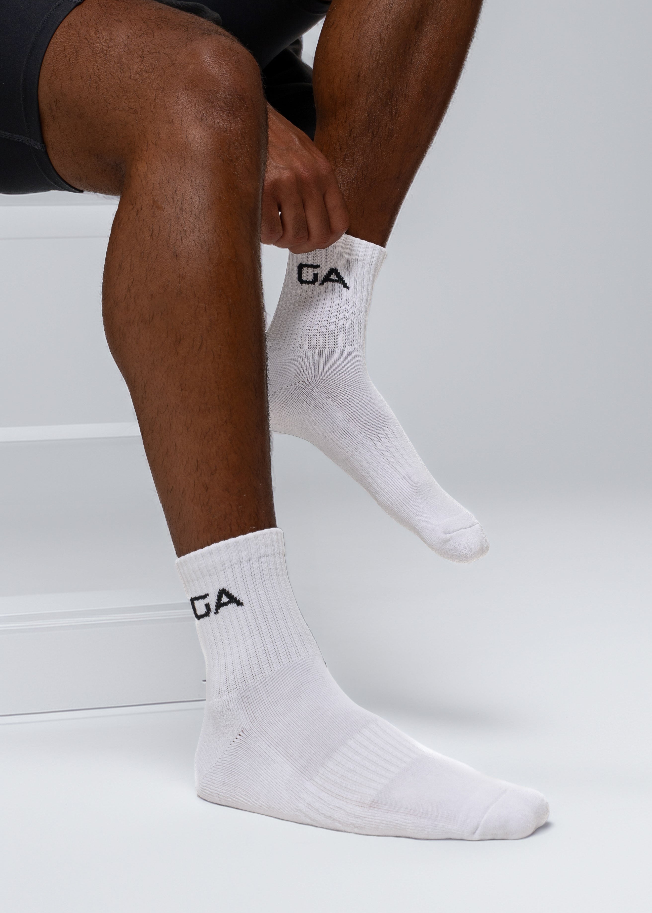 Person wearing white socks with a logo on a white background - GA Endurance Socks Gymathlete