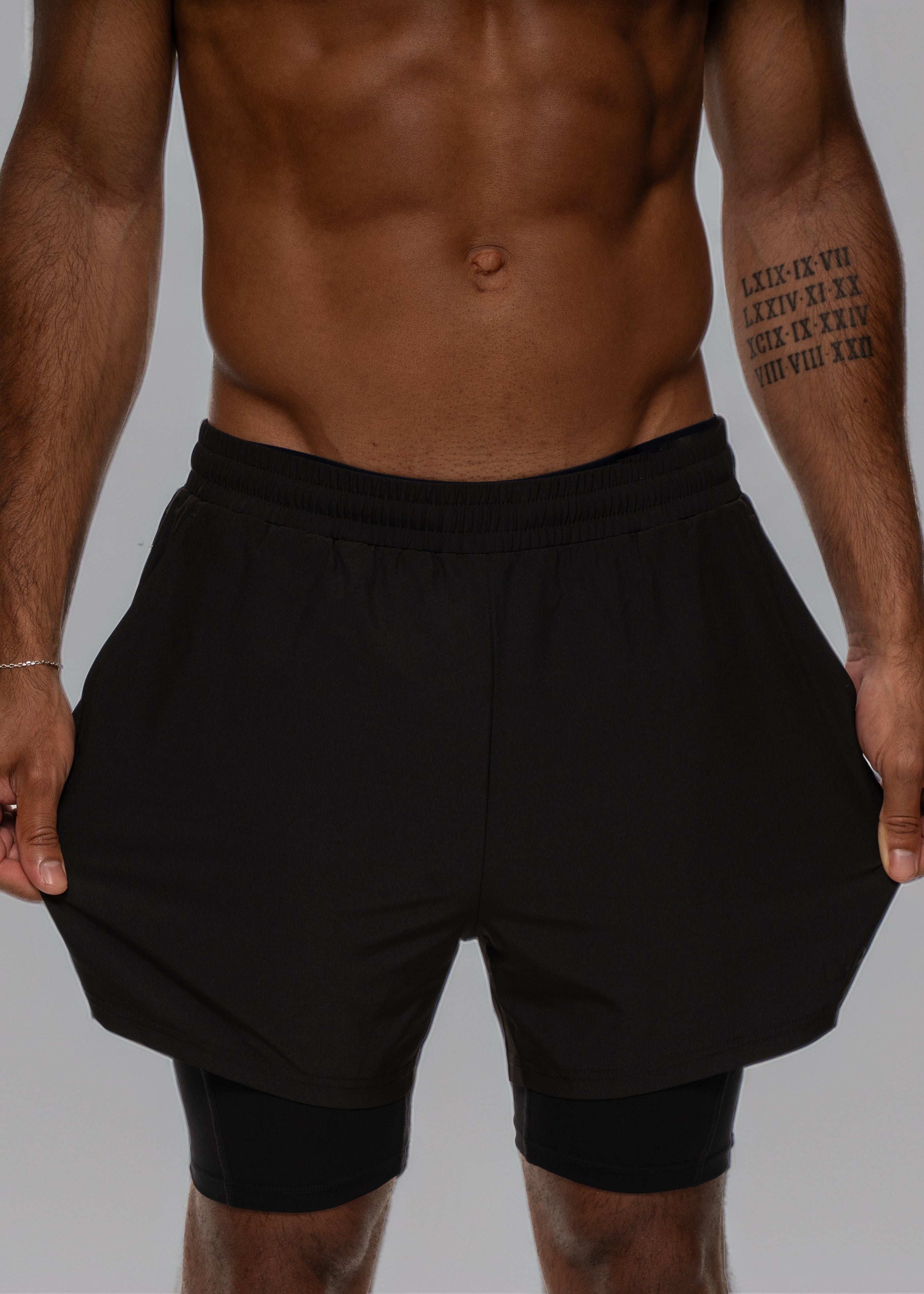 Man wearing black athletic shorts on a white background - Gymathlete 2in1 Shorts