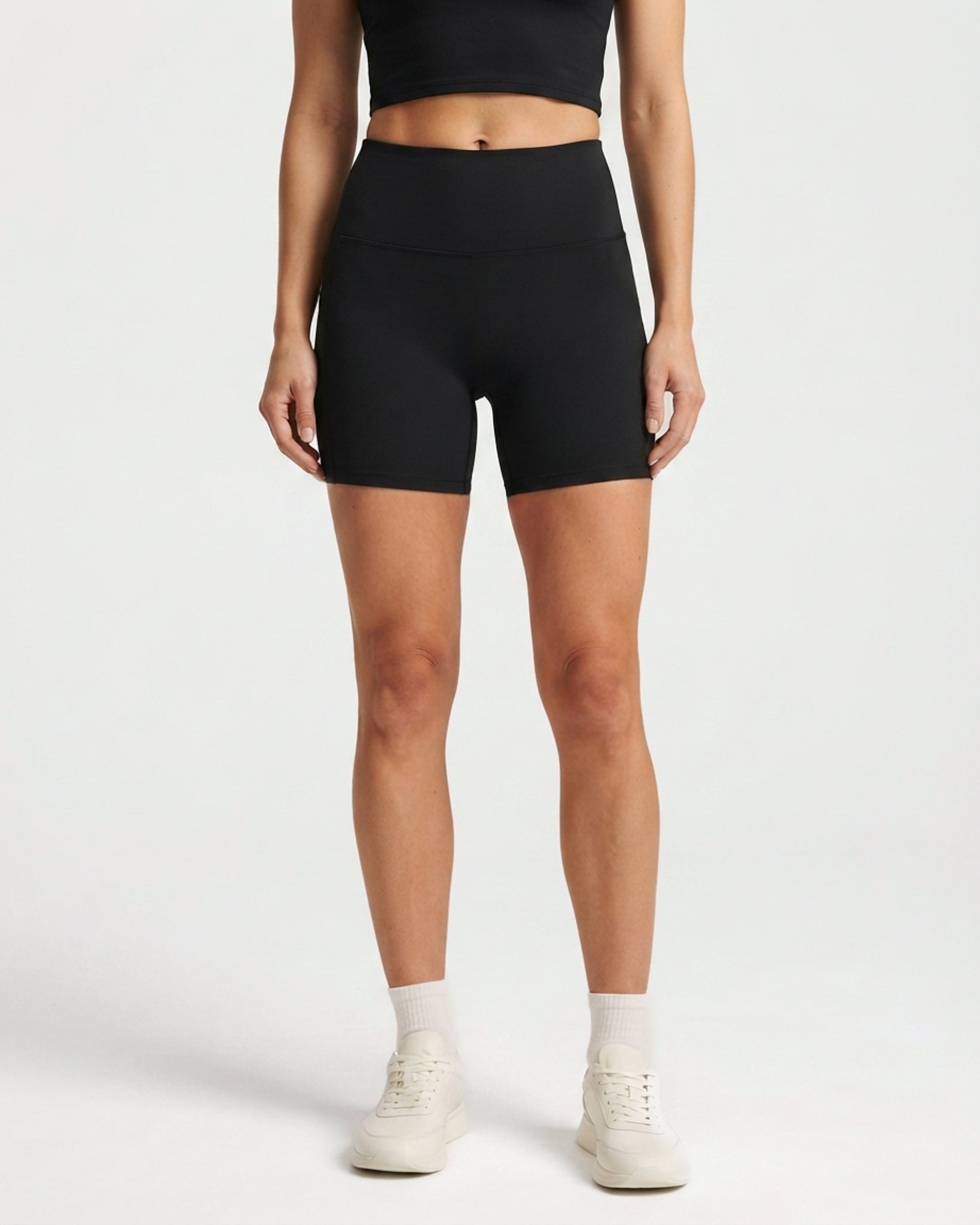 Black Gymathlete Pulse high-waisted biker shorts with crop top, front view on a light studio background