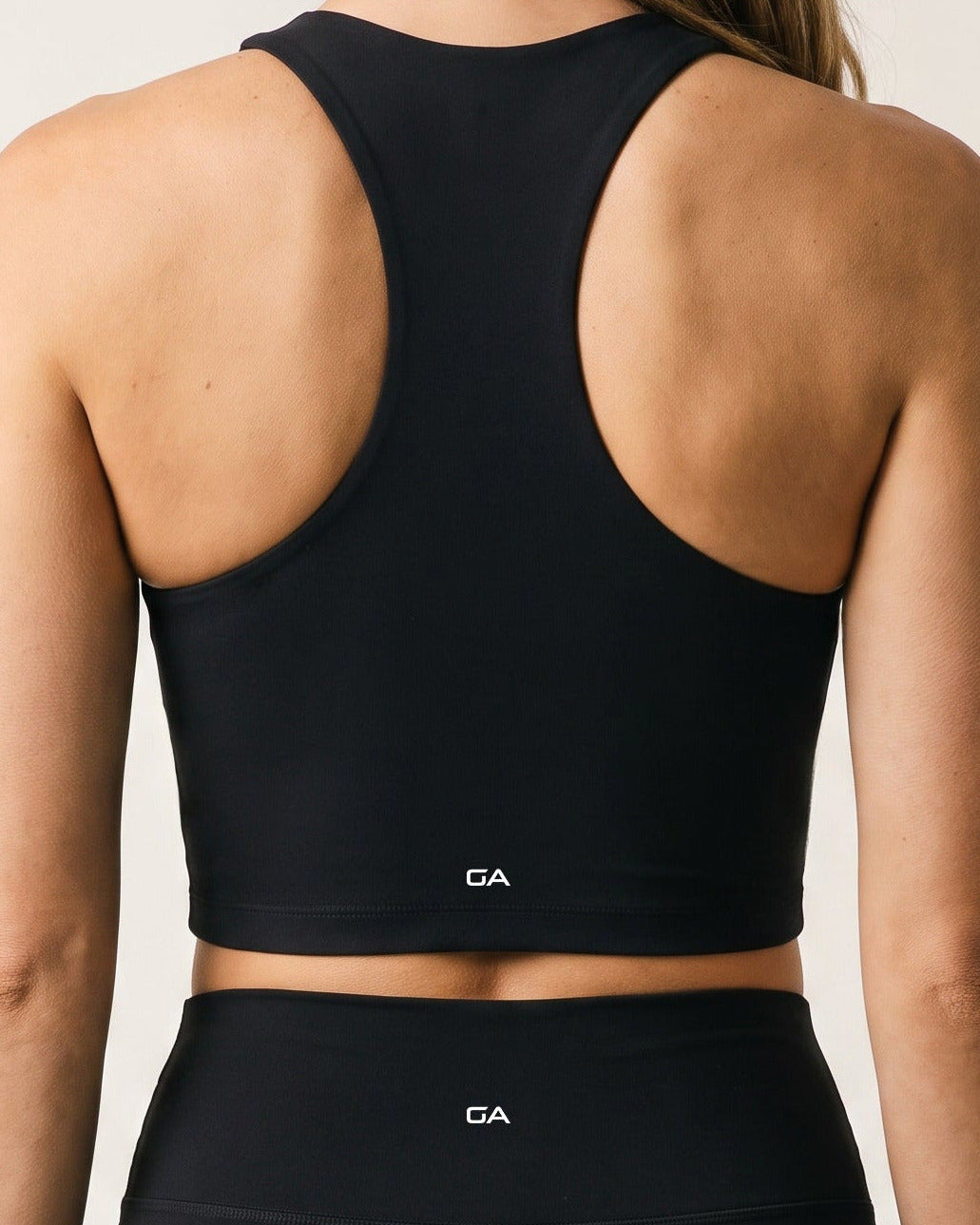 Back view of the Gymathlete Pulse Crop Top in black showing the racerback design and cropped length