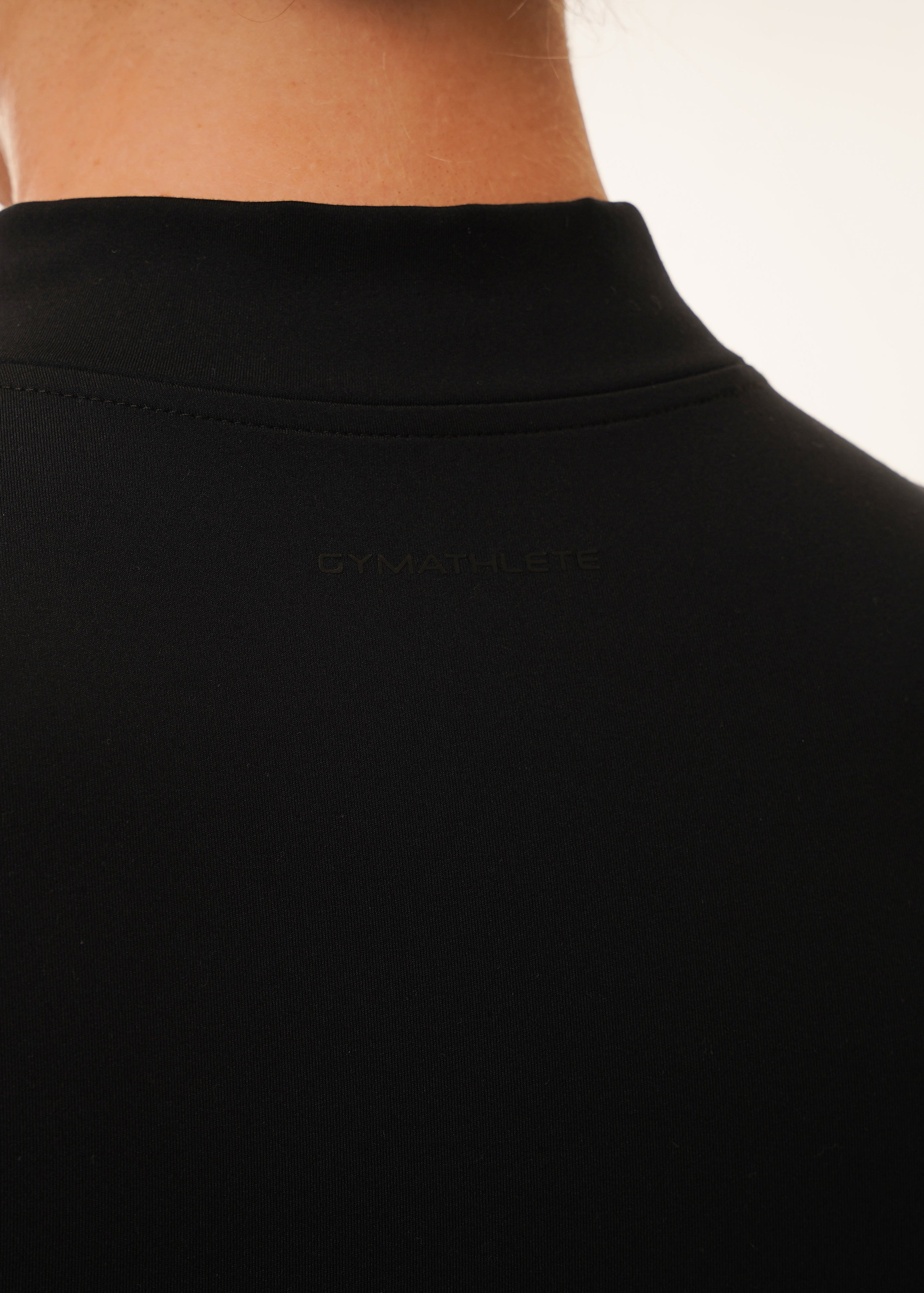 Woman wearing the Gymathlete Pulse Active Jacket in black. Activewear.